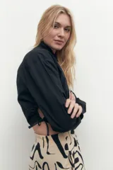 Camisa corta blanca de mangas largas con puños abotonados y cuello clásico.
