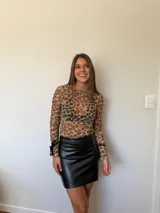Remera de microtul con estampado animal print de leopardo, cuello alto, mangas largas con lazos ajustables en los puños.