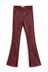 Pantalón de cuero sintético en color bordó, con corte acampanado y aberturas en el ruedo. Presenta costuras verticales decorativas en el frente.