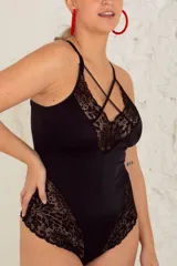 Body negro de lycra y puntilla elastizada, con tiras cruzadas en el frente, breteles regulables y broche en la entrepierna.