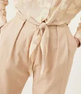 Camisa color beige con estampado geométrico, cuello camisero, manga larga y lazo frontal.
