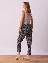 Pantalón negro con estampado geométrico blanco, de corte recto, con pretina ancha elastizada y lazo de ajuste.