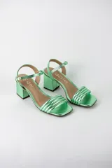 Sandalias de fiesta metalizadas color celeste, con taco cuadrado de 4 cm, tiras delanteras acolchadas y tira ajustable al tobillo con hebilla dorada.