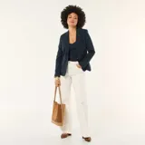 Jean de corte wide leg en color blanco, con diseño de cinco bolsillos y cierre frontal con botón y cremallera.