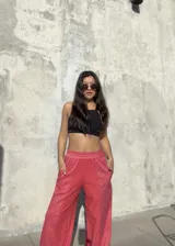 Pantalon de corte recto y holgado en color rojo, con cintura elastizada y bolsillos laterales funcionales. Presenta un diseño con costuras verticales que crean un efecto de relieve en el frente.
