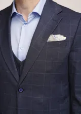 Traje de tres piezas Torelli color azul con sutil estampado a cuadros, compuesto por saco sastrero, chaleco abotonado y pantalón de vestir de corte recto.