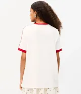 Remera blanca de algodón con mangas cortas, cuello redondo y ribetes rojos en contraste. Presenta estampa frontal de Strawberry Shortcake y lettering con texto en inglés y rojo.