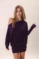 Vestido corto color violeta oscuro, con escote asimétrico, manga larga con orificio para el pulgar y corte ajustado.