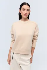 Sweater crudo de lana con cuello redondo y mangas raglán.