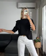 Blusa de símil lino color beige, con cuello redondo fruncido, doble volado en los hombros con detalle de encaje y manga 3/4.