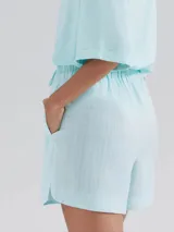 Short de cintura alta con elástico y cordón ajustable, confeccionado en tela ligera con textura, de corte holgado y ruedo redondeado.