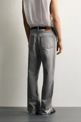 Jeans flare fit de denim negro, tiro medio, ajustados arriba y con botamanga acampanada. Cuentan con cinco bolsillos, lavado efecto gastado y bajo con acabado irregular. Cierre frontal con cremallera y botón.