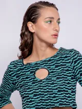 Top corto negro con estampado de líneas onduladas blancas, mangas 3/4 y abertura circular en el pecho.