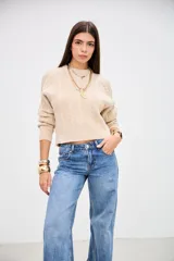 Sweater de punto con diseño de trenzas, color beige, de corte cropped y cuello redondo.
