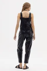 Pantalón negro de lino metalizado, corte recto y tiro medio.