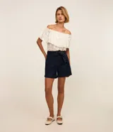 Short tipo mom de jean azul marino con cintura alta, bolsillos delanteros y cinturón ajustable confeccionado en la misma tela con pespuntes visibles.