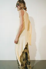 Top asimétrico de mezcla de lyocell en color amarillo claro, con cuello redondo y diseño fluido de corte irregular con una manga larga y un lateral drapeado.