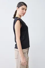 Remera color pistacho con cuello en V y botones decorativos en los hombros.