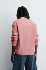 Polo de manga larga con tejido de punto de algodón con estructura tipo waffle. Presenta cuello solapa y cierre frontal con botonadura, con un acabado de efecto lavado.