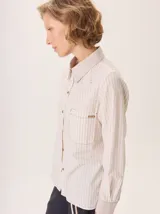 Camisa de manga larga con diseño combinado. Presenta mangas y parte superior delantera y trasera en color negro liso, mientras que el panel central de la espalda destaca por un estampado animal print de leopardo. Cuenta con cuello clásico, cierre frontal de botones y puños abotonados.