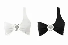 Top asimétrico de un solo hombro, con detalle metálico central en forma de concha marina que une las dos piezas de tela. Diseño minimalista y elegante.