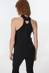 Top de cuello halter confeccionado con parches de cuero negro unidos mediante tejido de punto a crochet, creando un diseño geométrico de rombos.