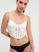 Corset blanco de encaje con copas con aros y breteles finos regulables.