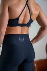 Calza deportiva de tiro alto con corte oxford, confeccionada en poliamida y elastano. Presenta un diseño ajustado en la parte superior y ligeramente acampanado en los tobillos con aberturas laterales.