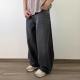 Pantalón jean de corte barrel, color azul clásico con efecto desgastado y diseño amplio y curvado en las piernas.