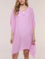 Vestido playero tipo túnica de corte holgado color rosado, confeccionado en tejido semi transparente con textura sutilmente arrugada. Cuenta con escote en V pronunciado, mangas estilo kimono de caída fluida y aberturas laterales en el ruedo irregular.