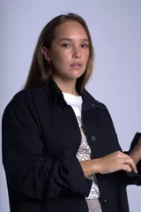 Sobrecamisa color beige confeccionada en gabardina, de corte holgado, con cuello camisero, cierre frontal con botones, dos bolsillos de parche en el pecho y mangas largas con puños abotonados.