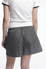 Short de popelina de algodón con estampado de rayas verticales celestes y blancas, cintura elastizada y bolsillos laterales.
