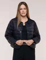 Campera puffer corta de diseño reversible y liviano, marca Michael Kors. Cuenta con acabado resistente al agua, diseño acolchado con matelaseado horizontal, cuello redondo a la base sin solapa ni capucha, cierre frontal completo con botones de presión metálicos, bolsillos laterales funcionales y ribetes a tono. Largo a la cintura y empacable en su propia bolsa de guardado.