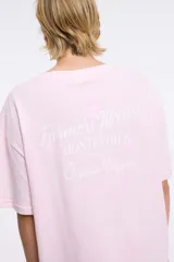 Remera de corte oversized en color blanco, con cuello redondo y mangas cortas. Presenta una estampa central con la frase 'Living a hot life' y un diseño de ajíes rojos.