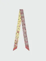 Cinta de seda Longchamp modelo Frise Fleurie, con diseño reversible de estampado floral, combinando un lado en tonos amarillos y otro con densas flores rojas y rosadas.