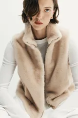 Chaleco de efecto pelo con cuello subido, diseño sin mangas y cierre frontal con cremallera metálica.