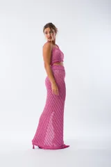 Pollera midi de tejido de punto con diseño acanalado diagonal, tiro alto y tajo lateral profundo. Presenta un acabado con flecos en el ruedo.