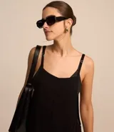 Mono largo negro de viscosa con breteles finos ajustables, escote cuadrado y bolsillos cargo laterales.