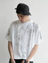 Remera de algodón pesado con corte boxy fit, color blanco con efecto acid wash. Presenta un estampado frontal y en mangas que simula una armadura medieval con acabado gastado.