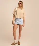 Remera cropped de manga corta, cuello redondo y calce oversized, confeccionada en tejido de algodón tipo media malla.