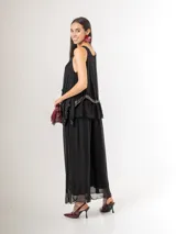 Pantalón de seda italiana con forro de viscosa elastizada, de corte holgado y diseño fluido, con detalles de paillettes en los costados y cintura elastizada.