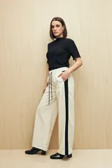 Pantalón de corte recto color negro con franjas laterales blancas a contratono. Cuenta con cintura elástica, cordones de ajuste y bolsillos laterales.