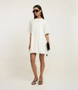 Vestido estilo camiseta de algodón, con cuello redondo, mangas cortas y diseño oversized con efecto balonê en el ruedo.