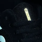 Championes urbanos Öus modelo Cuoro, color negro con detalles en blanco. Presentan un diseño de corte bajo con logo lateral distintivo, confeccionados en una combinación de gamuza y malla, con suela de goma blanca.