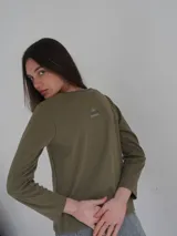 Remera manga larga color verde seco, de corte recto y cuello redondo.