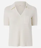 Blusa de manga corta en punto de algodón color crudo, con cuello polo, escote en V y un bolsillo aplicado en el frente.