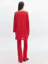 Pantalón negro de corte flare, con aberturas en el ruedo y cintura con elástico.