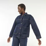 Campera vaquera azul oscuro con bolsillos de parche delanteros, cierre frontal de botones metálicos y costuras contrastantes en tono tostado.