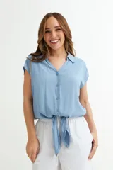 Camisa celeste con cuello, abotonada al frente y mangas cortas.