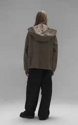 Campera técnica liviana color beige, confeccionada en microfibra de alta densidad con acabado mate. Presenta mangas desmontables que permiten convertirla en chaleco, cuello tipo camisa, cierre frontal oculto bajo cartera y logo bordado en el pecho. Incluye cuatro bolsillos frontales de gran tamaño con solapa y puños con elástico.